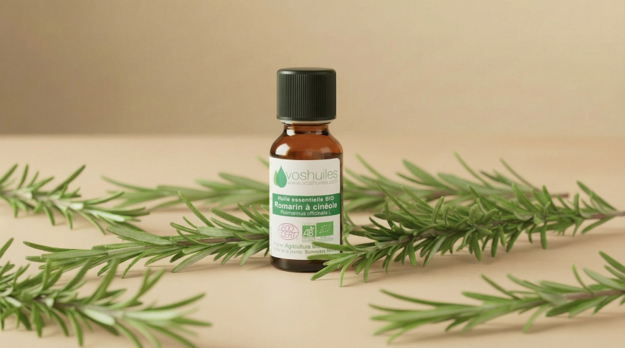 Flacon d’huile essentielle bio de romarin cinéole entouré de branches de romarin.